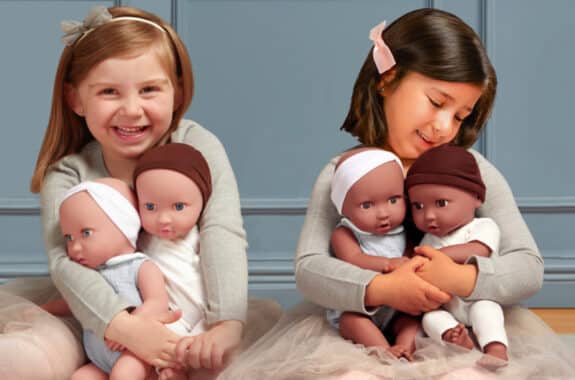 two girls each hold two baby doll twins 