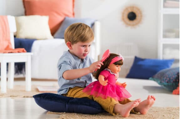 boy brushing baby dolls hair