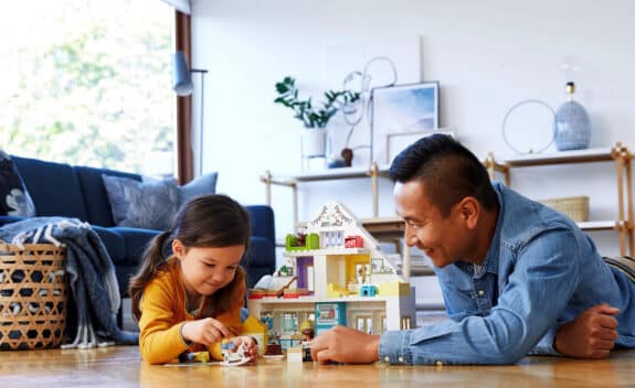 dad and daughter building lego dollhouse.