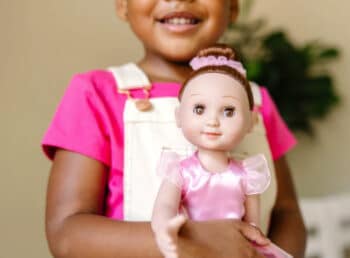 little girl holding a ballerina doll