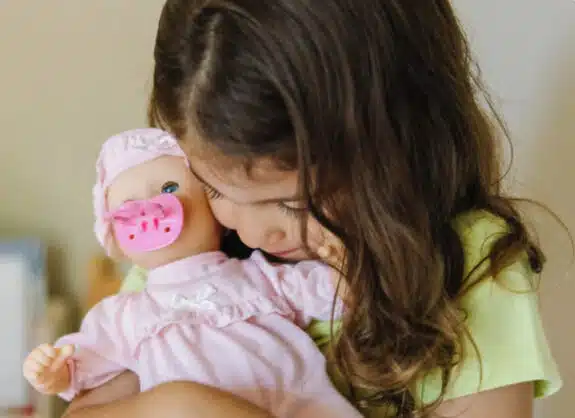 little girl cuddling her doll