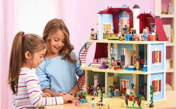 two girls play with playmobil playhouse