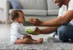 Father Feeding His Adorable Infant Baby Son With Spoon