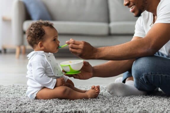  Father Feeding His Adorable Infant Baby Son With Spoon