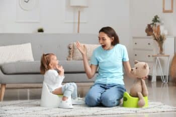 Mother potty training her little daughter at home