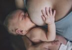 Mother breastfeeding her newborn baby boy