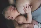 Mother breastfeeding her newborn baby boy