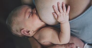 Mother breastfeeding her newborn baby boy