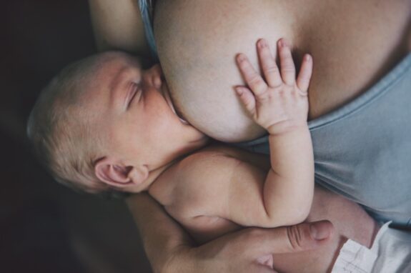 Mother breastfeeding her newborn baby boy