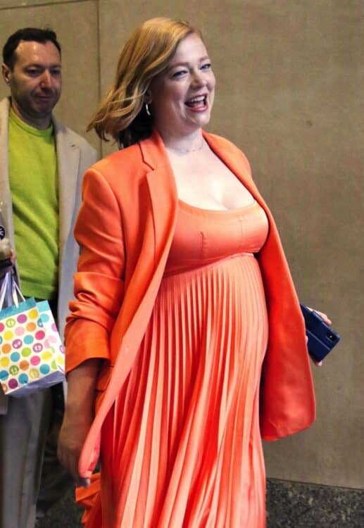 pregnant sarah snook walking out of today's show in a orange flowing crepe dress with matching blazer.