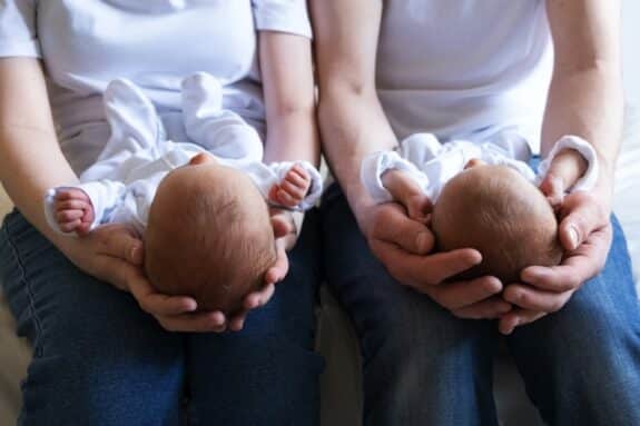 Infant twins being held by two parents