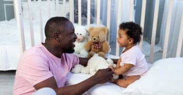 dad and baby son talking in the bedroom at home