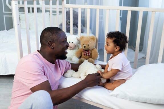 dad and baby son talking in the bedroom at home