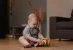 infant playing with stacking toys