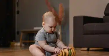 infant playing with stacking toys