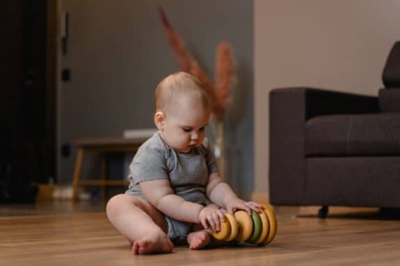 infant playing with stacking toys
