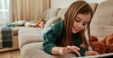 Preschool girl using a tablet computer at home