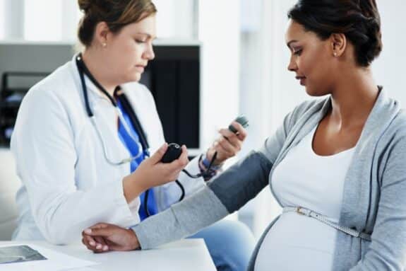 wellness check and a medical worker with a patient consulting about hypertension during pregnancy