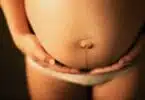 A pregnant woman holding her stomach