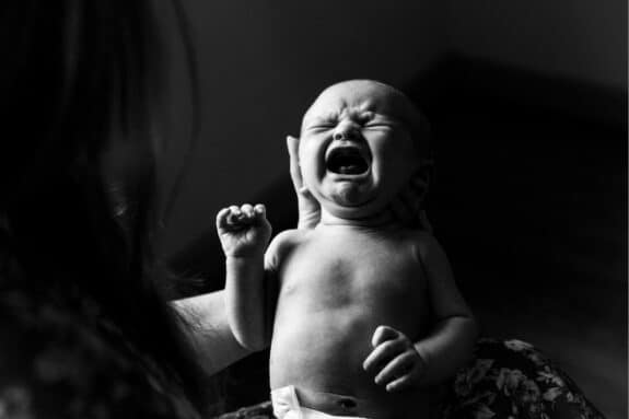 NEWBORN IN MOM'S ARMS CRYING