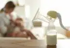 breast feeding mom with breast pump in forefront