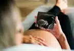 pregnant woman holding ultrasound picture
