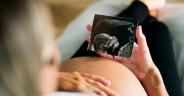 pregnant woman holding ultrasound picture