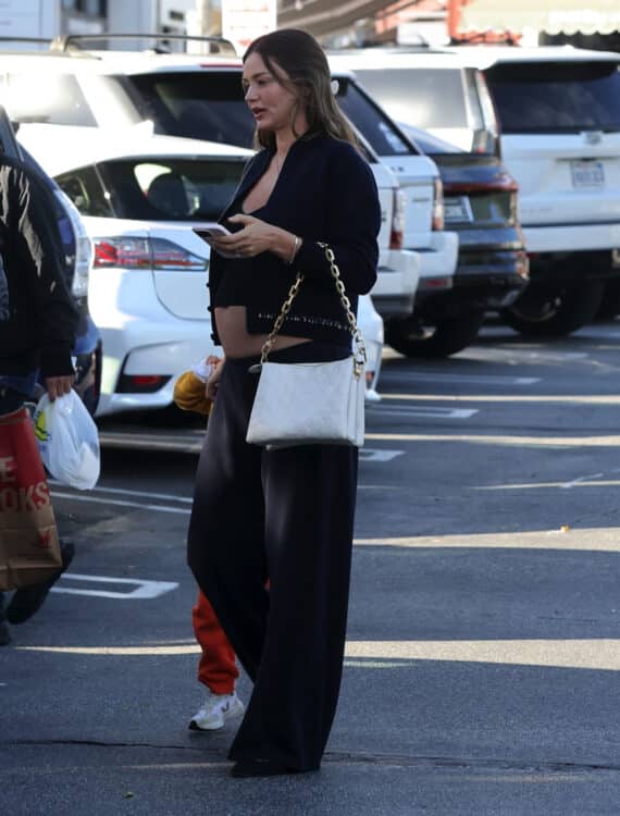 Pregnant Miranda Kerr walking to her car in Los Angeles wearing black pants, tank and crop sweater