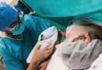 doctor showing newborn baby to mother