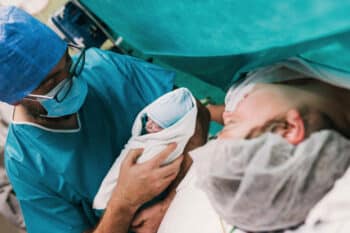 doctor showing newborn baby to mother