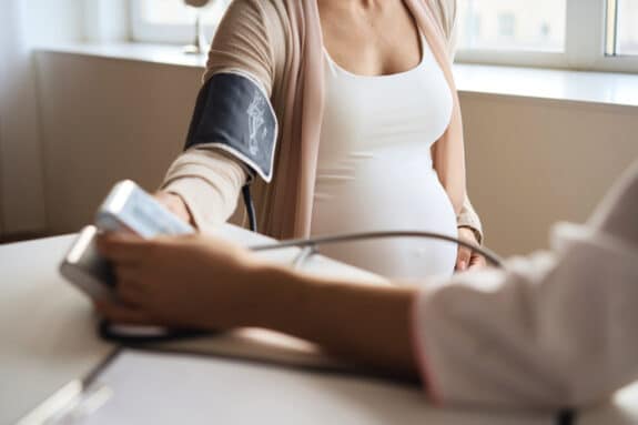 Doctor measuring blood pressure of her pregnant patient