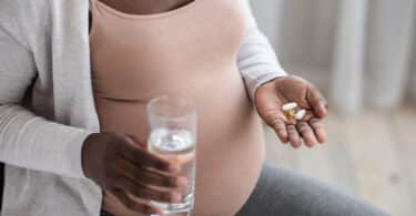 pregnant woman taking pills and water