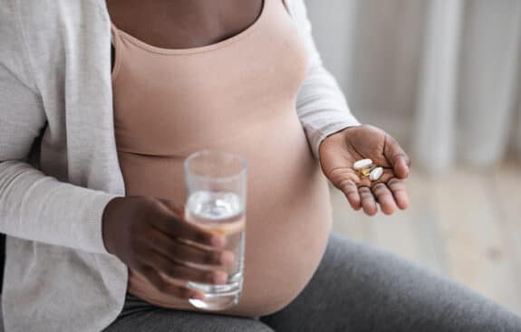 pregnant woman taking pills and water