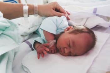 Mother and newborn resting after childbirth in maternity hospital room