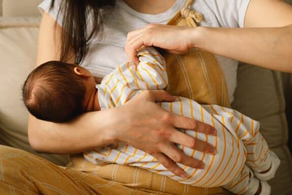 Newborn baby boy nursing from mothers breast