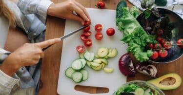 pregnant woman chopping vegetables for meal