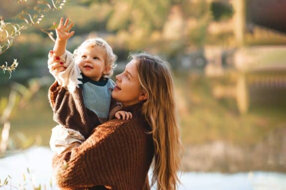 Happy mom holding baby outdoor