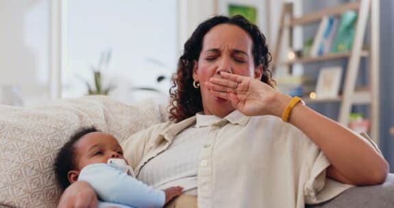 Woman, baby and tired yawn in home for mother parenting fatigue