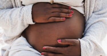 african pregnant woman holding her belly
