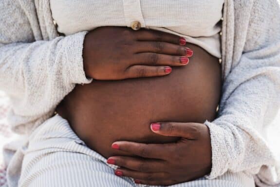 african pregnant woman holding her belly