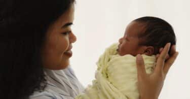 mother holding her newborn baby with happy face