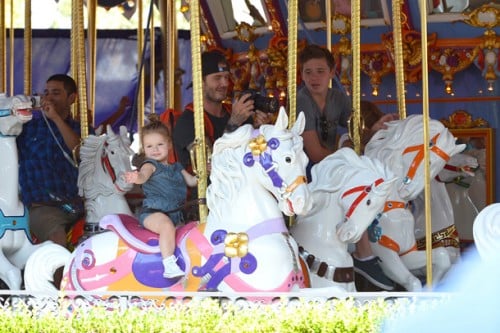 David Beckham on the carousel at Disneyland with his kids Brooklyn and Harper