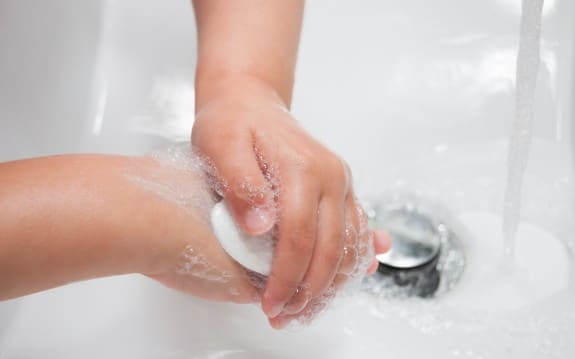 Child washing hands with soap