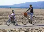 Naomi Watts bikes at the beach with her son Sammy