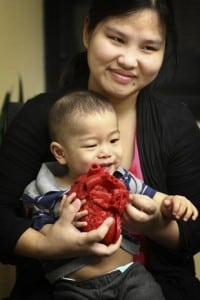 Roland Lian Cung Bawi 14 months holds a 3D model of his heart