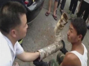 Rescuers try to reach the trapped infant inside the cut away sewage pipe in Jinhua City, Zhejiang Province