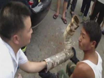 Rescuers try to reach the trapped infant inside the cut away sewage pipe in Jinhua City, Zhejiang Province