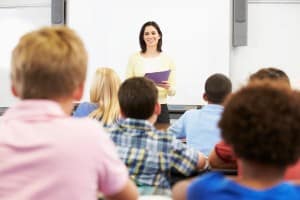 Teacher Standing In Front Of Class Of Pupils